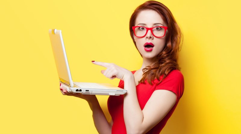 a girl in red dress holding a laptop